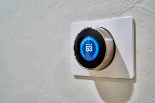 Ein moderner Thermostat ist an der Wand montiert und zeigt die Temperatur im Raum an.