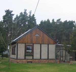 Ein Haus in Holzständerbauweise erbaut steht auf einer grünen wiese